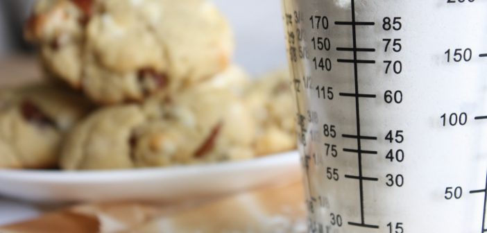 clear glass measuring cup on white ceramic plate