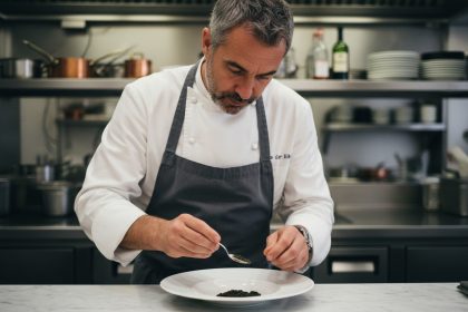 Chef français en blanc sert du caviar sur une assiette